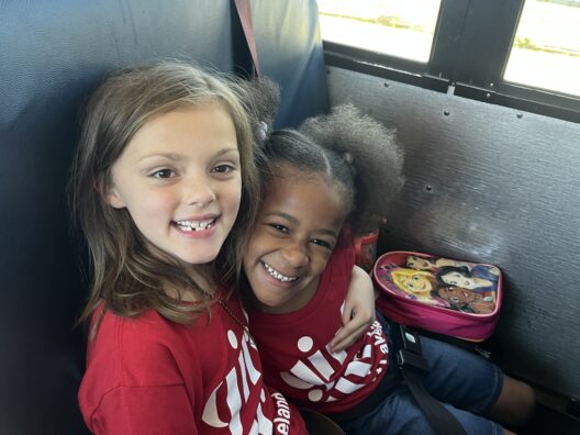 Two girls smiling on bus ride